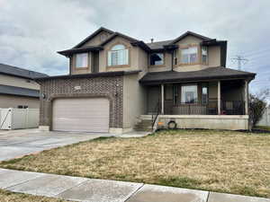 View of front of property featuring stucco siding, concrete driveway, an attached garage, and fence