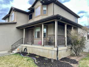 View of front of home featuring stucco siding and a porch