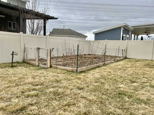 View of yard with a garden and fence