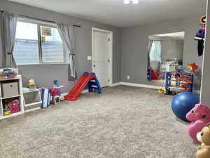 Playroom featuring baseboards and carpet