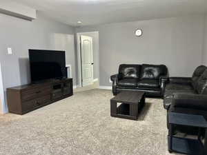 Carpeted living area featuring baseboards