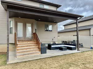 Back of property featuring an outdoor living space, fence, entry steps, and a patio area