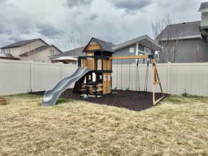 View of play area featuring a yard and a fenced backyard