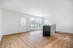 Foyer entrance featuring parquet floors and baseboards