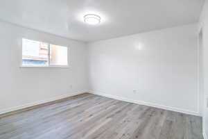 Spare room with light wood-type flooring and baseboards