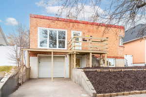 View of front of house with brick siding, stucco siding, driveway, and a garage