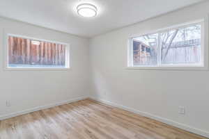 Spare room featuring baseboards and wood finished floors