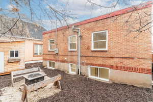 Back of property featuring a fire pit and brick siding