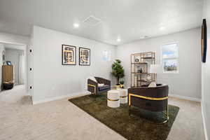 Interior space with visible vents, baseboards, and light colored carpet