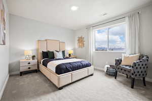 Bedroom with visible vents, light carpet, and baseboards
