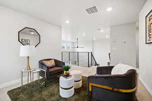 Sitting room with visible vents, an upstairs landing, recessed lighting, carpet, and baseboards
