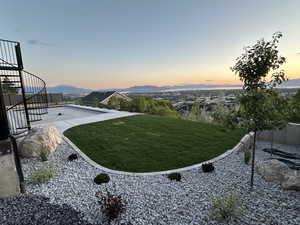 Yard at dusk featuring stairs, a yard, and a mountain view