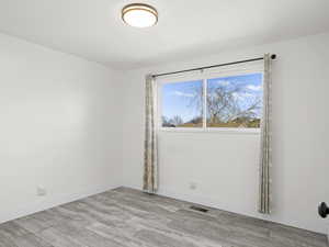 Empty room featuring light wood-type flooring and baseboards