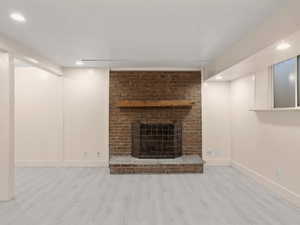 Unfurnished living room with recessed lighting, baseboards, wood finished floors, and a fireplace