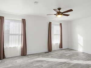 Spare room with baseboards, ceiling fan, and light wood finished floors