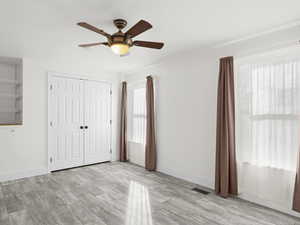 Unfurnished bedroom featuring a ceiling fan, baseboards, visible vents, and a closet