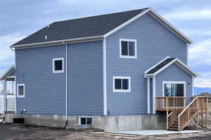 Rear view of property featuring a deck and stairs