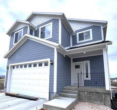 Traditional-style home featuring covered porch and a garage