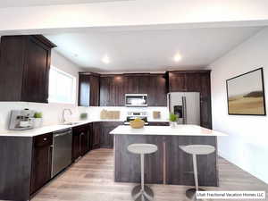 Kitchen with stainless steel appliances, a kitchen island, and light countertops