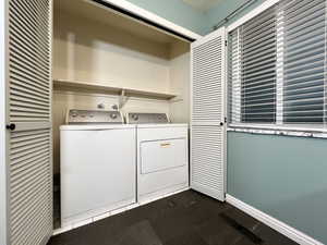 Washroom with laundry area, baseboards, and washer and clothes dryer