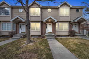 Multi unit property featuring brick siding and a front yard