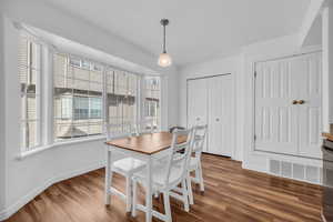 Dining space featuring visible vents, baseboards, and wood finished floors