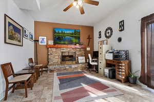 Living area featuring ceiling fan and a fireplace