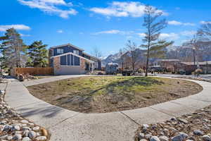 Exterior space featuring stone siding, fence, concrete driveway, a garage, and brick siding