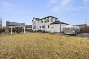 Rear view of property with a gazebo, a patio area, a lawn, and fence