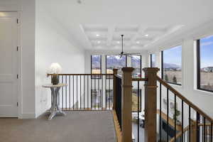 Corridor featuring baseboards, coffered ceiling, recessed lighting, light carpet, and beamed ceiling