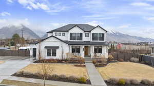 Modern farmhouse style home featuring driveway, a gate, a porch, fence, and a mountain view