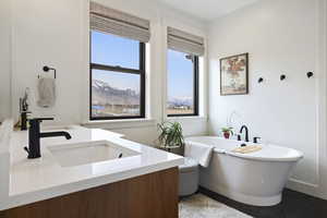 Bathroom featuring tile patterned flooring, a freestanding tub, and vanity