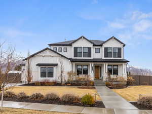 View of front of property with board and batten siding and fence