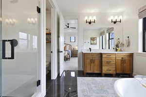 Bathroom featuring toilet, ensuite bathroom, an enclosed shower, vanity, and a ceiling fan