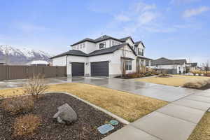 View of front facade with a gate, fence, roof with shingles, concrete driveway, and a mountain view