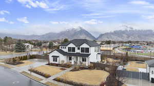 View of front of house with a fenced front yard, covered porch, a mountain view, and a gate