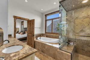 Bathroom with a shower stall, ensuite bathroom, a garden tub, and a sink