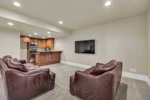 Living area with recessed lighting, baseboards, and light carpet