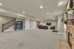 Living area with stairway, recessed lighting, baseboards, and light carpet