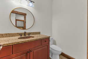 Bathroom featuring toilet, vanity, and baseboards