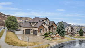 French country inspired facade featuring a gate, fence, stucco siding, concrete driveway, and stone siding