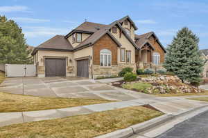 Craftsman house featuring a shingled roof, concrete driveway, stucco siding, an attached garage, and a gate