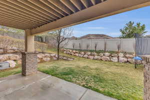 View of yard featuring a patio area, fence, and a mountain view