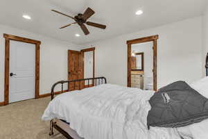 Bedroom featuring recessed lighting, baseboards, ensuite bathroom, and light carpet