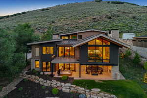 Back of house with a patio, a chimney, a standing seam roof, and a metal roof