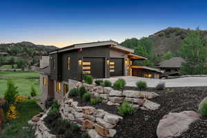 View of front of property featuring a mountain view, a garage, driveway, and a front yard