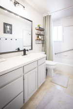 Bathroom with vanity, toilet, and shower / tub combo with curtain