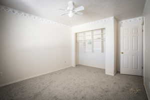 Unfurnished bedroom with a ceiling fan, carpet, a closet, and baseboards