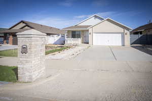 Ranch-style house featuring a gate, fence, driveway, a garage, and brick siding