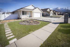 View of front of home with a front yard, fence, driveway, a garage, and brick siding